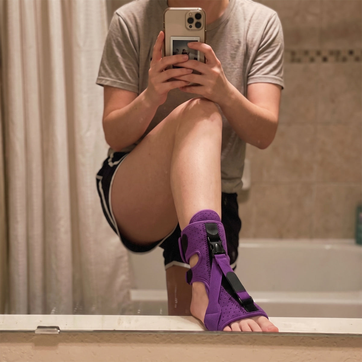 The purple night splint worn on the foot, photographed in a bathroom mirror